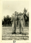 Two Soldiers Pose in Front of Palm Trees